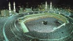 Thousands encircle the black stone, while an Imam speaks as the oracle of Allah.